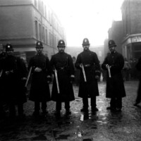 Police wielding shotguns are deployed near the suspected hiding place of the gang.